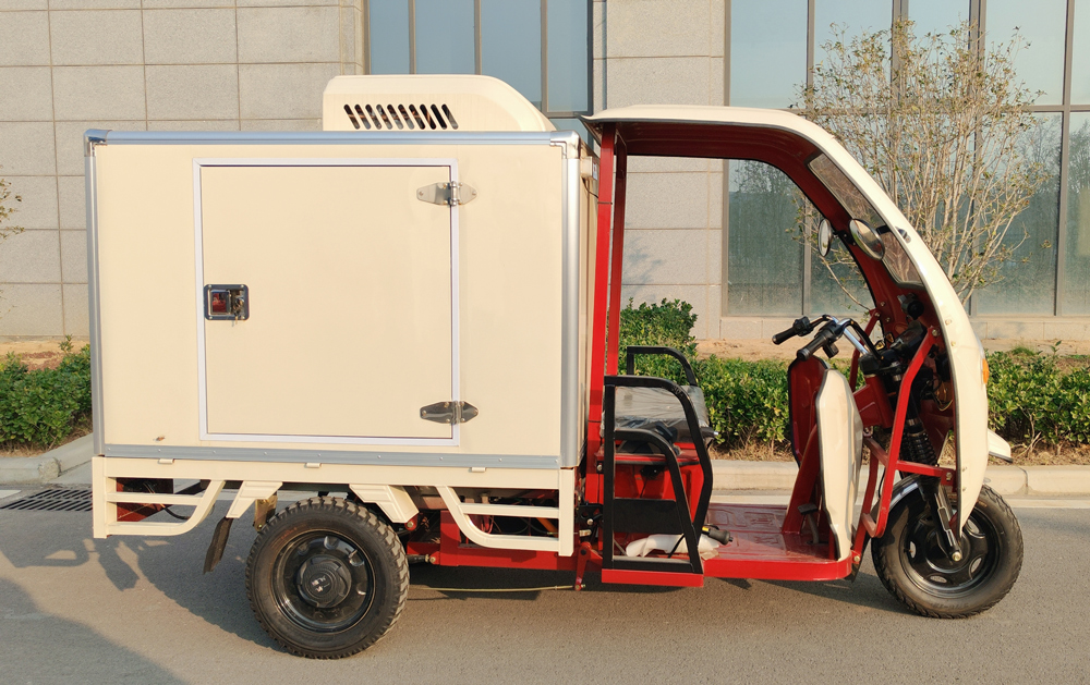Red and white electric refrigerated tricycle with an enclosed cargo box